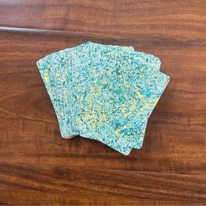 Deck of playing cards with blue yellow and green speckled paint design